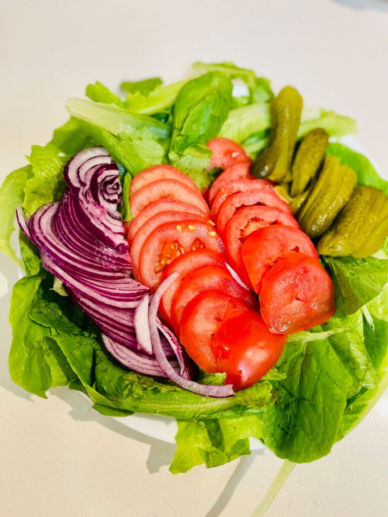 vegetable platter with lettuce, tomatoes, pickles and onions